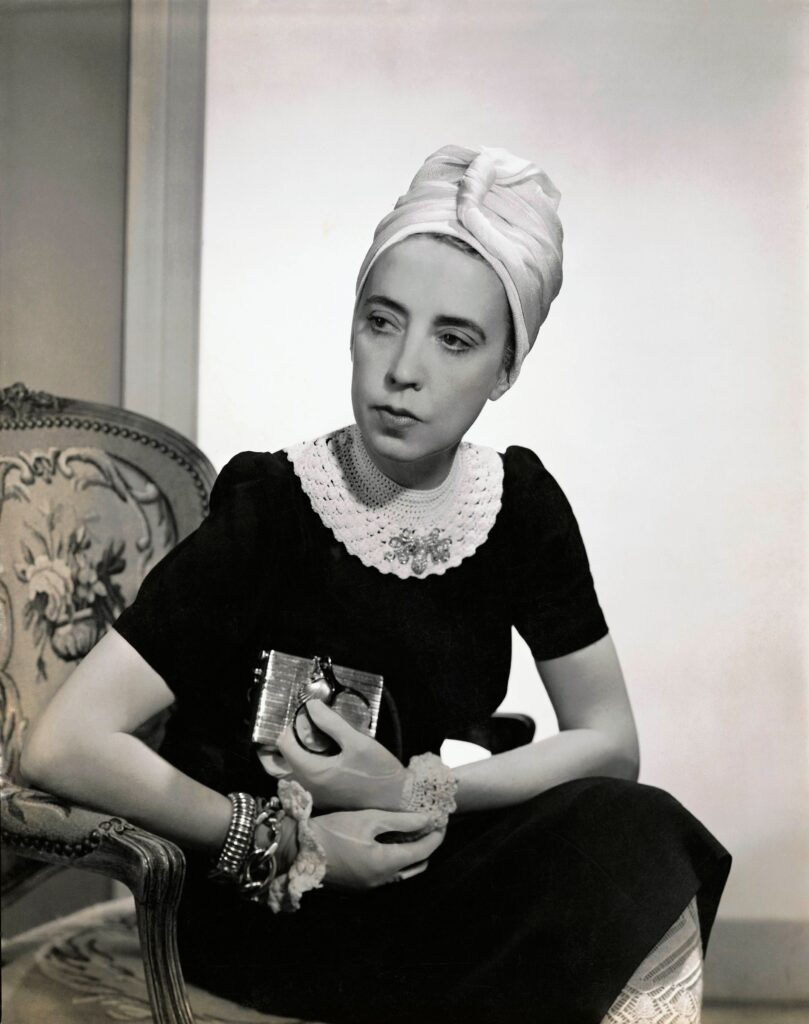 Vogue 1940; Designer Elsa Schiaparelli wearing black silk dress with crocheted collar of her own design and a turban (Photo by Fredrich BakerCondé Nast via Getty Images).jpg
